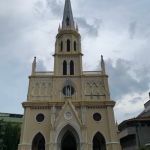 Holy Rosary Church's Gothic Revival spire overlooking the Chao Phraya River in Talat Noi, Bangkok